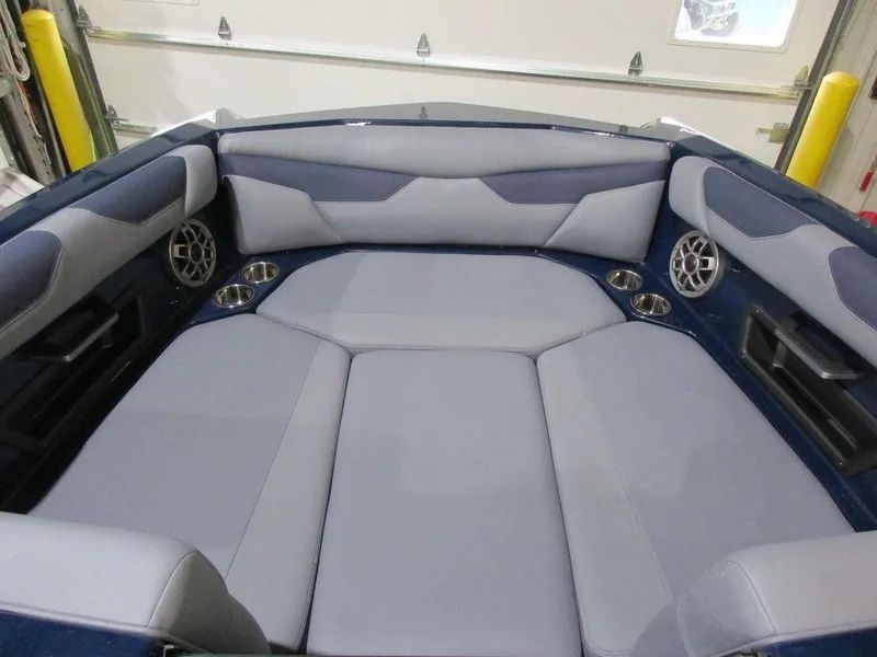 Slide: The Image of 2023 Axis A24 boat interior with gray and blue seating, cup holders, and speakers. - 6