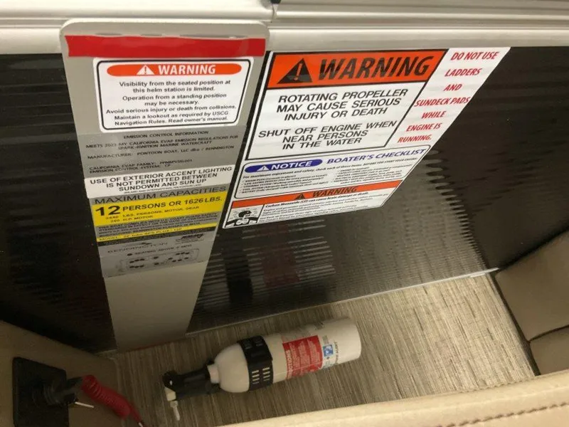 Slide: The Image of Warning labels and fire extinguisher on a 2023 Bennington 23 LSR boat. - 18