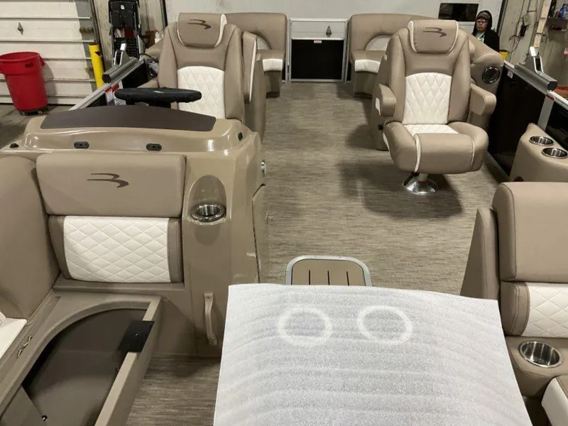 Slide: The Image of 2023 Bennington 23 LSR pontoon boat interior with beige and white seating. - 23