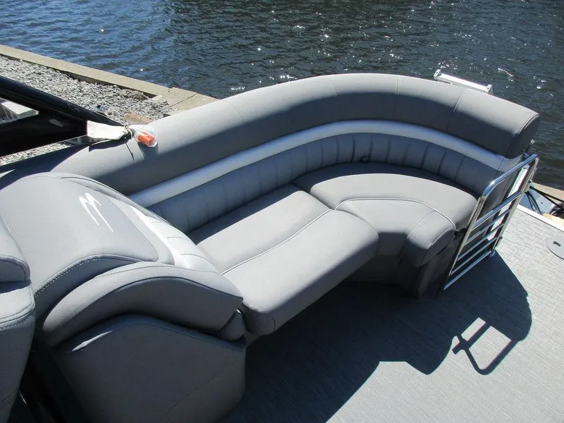 Slide: The Image of 2023 Bennington 24 LXFBA boat with luxurious gray seating by the water. - 13