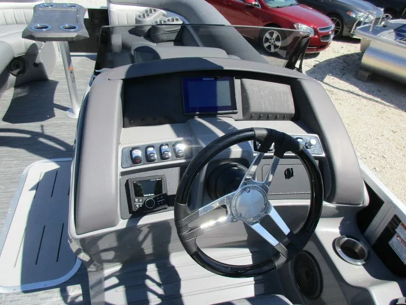 Slide: The Image of 2023 Bennington 24 LXFBA boat dashboard with steering wheel and control panel. - 4