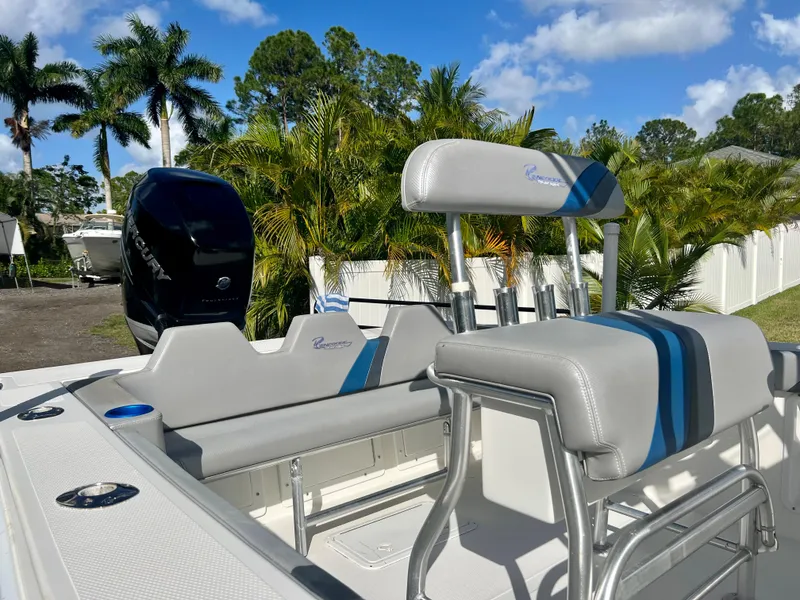 Slide: The Image of 2016 Renegade 250 boat with seating and outboard motor, surrounded by palm trees. - 17
