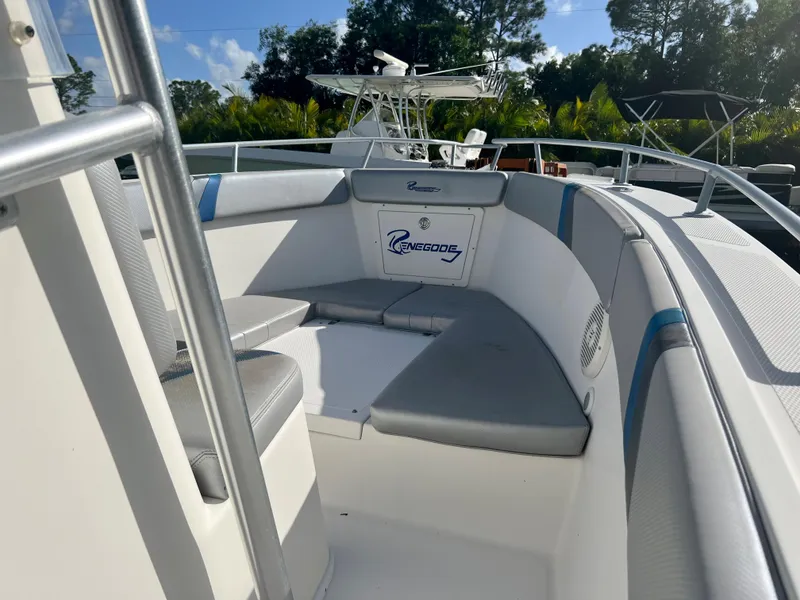 Slide: The Image of 2016 Renegade 250 boat with cushioned seating and logo, docked outdoors. - 19