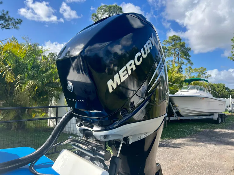 Slide: The Image of Mercury outboard motor on a 2016 Renegade 250 boat, parked outdoors. - 20