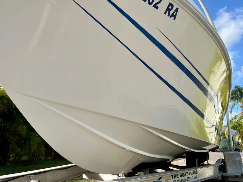 Slide: The Image of 2016 Renegade 250 boat on trailer, close-up view of hull and blue stripes. - 22