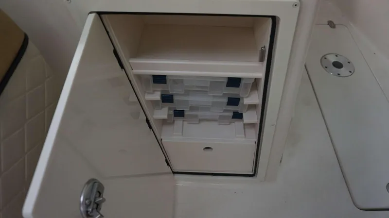 Slide: The Image of Storage compartment with tackle boxes on a 2023 Sea Chaser 27 HFC boat. - 12