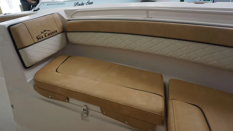 Slide: The Image of 2023 Sea Chaser 27 HFC boat interior with tan and white cushioned seating. - 29