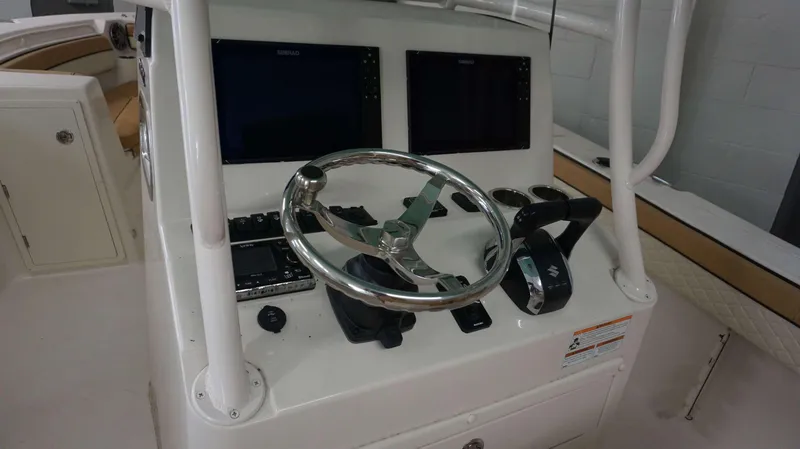 Slide: The Image of 2023 Sea Chaser 27 HFC boat helm with dual Simrad displays and stainless steel steering wheel. - 4