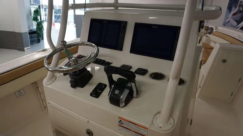 Slide: The Image of 2023 Sea Chaser 27 HFC boat console with dual Simrad displays and Suzuki controls. - 5