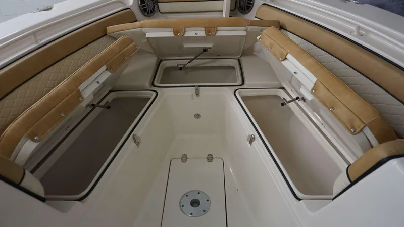 Slide: The Image of 2023 Sea Chaser 27 HFC boat interior with open storage compartments and cushioned seating. - 8