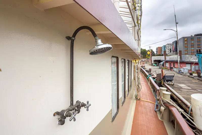 Slide: The Image of Exterior shower on 1943 Custom Navy Tugboat docked at urban marina. - 11