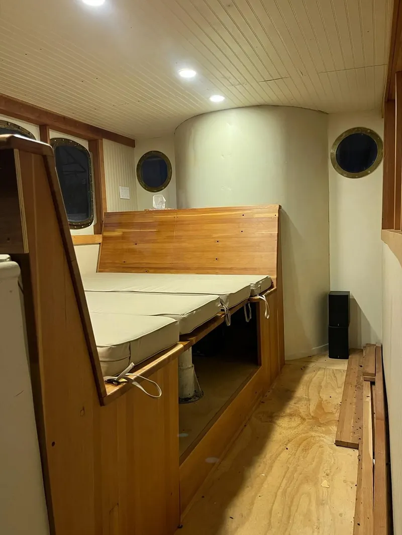 Slide: The Image of Interior of a 1943 Custom Navy Tug with wooden bed and porthole windows. - 16