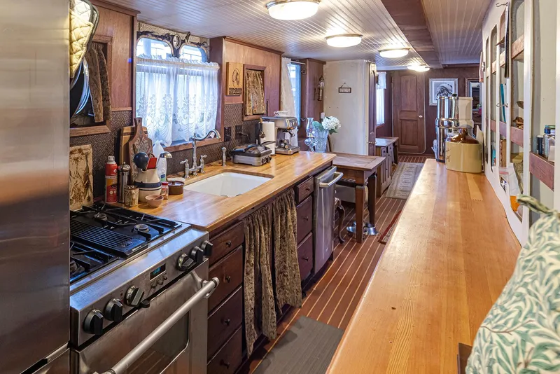 Slide: The Image of 1943 Custom Navy Tug interior with wooden countertops, stove, and cozy kitchen decor. - 20