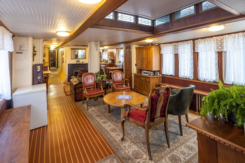 Slide: The Image of Interior of a 1943 Custom Navy Tug, featuring vintage furniture and wood paneling. - 23