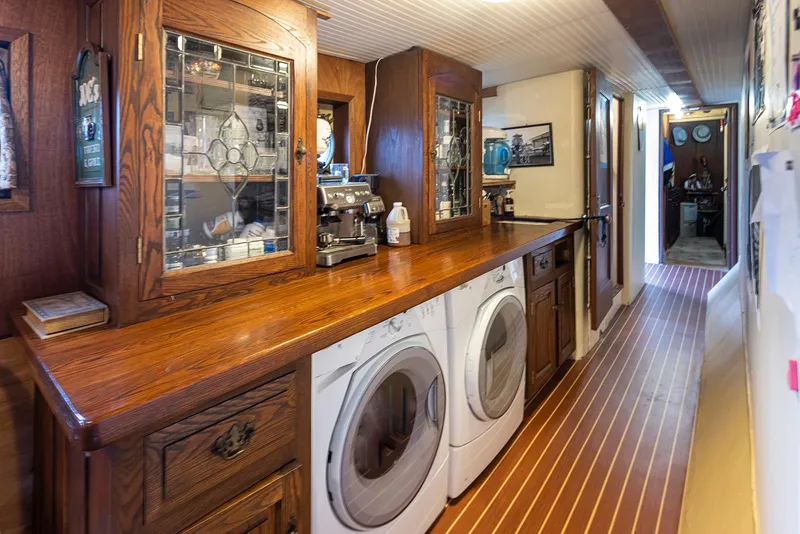 Slide: The Image of Laundry area with wooden cabinets and appliances on a 1943 Custom Navy Tug. - 26