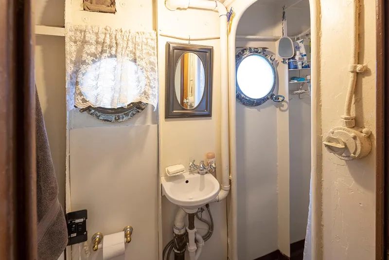 Slide: The Image of Vintage 1943 Navy tugboat bathroom with porthole windows and compact sink. - 28