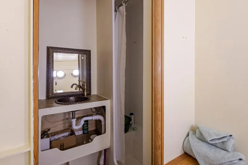 Slide: The Image of Small bathroom on a 1943 Custom Navy Tug with sink, mirror, and shower. - 35