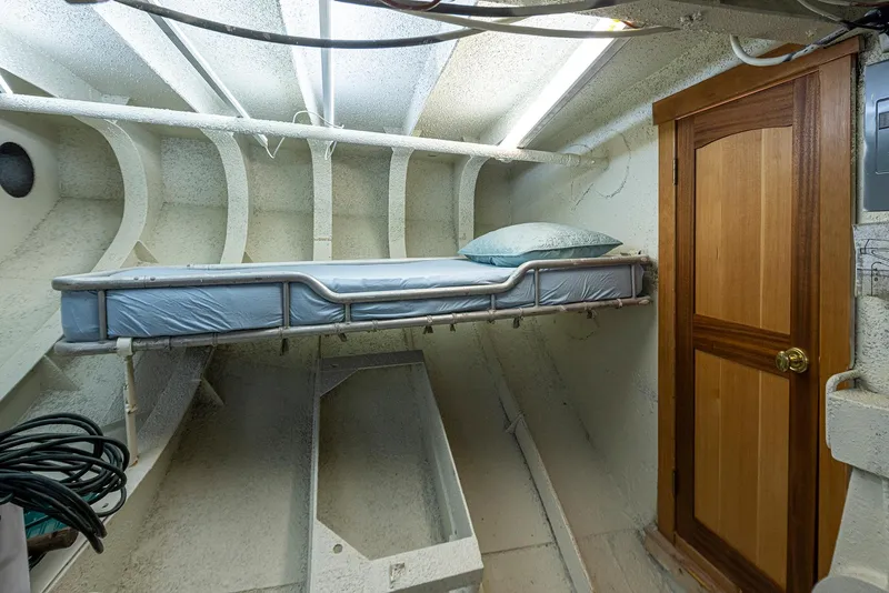 Slide: The Image of Interior of a 1943 Custom Navy Tug with a single bunk and wooden door. - 37