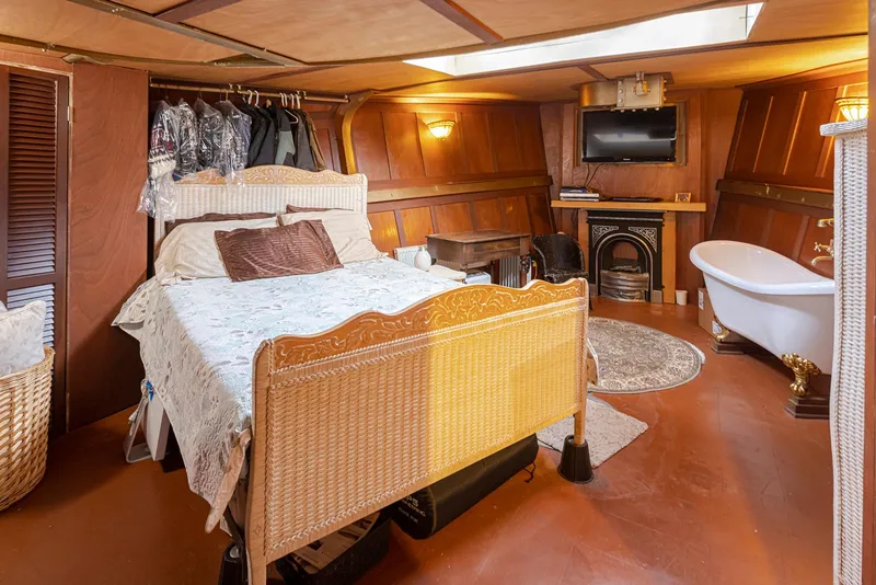 Slide: The Image of Cozy bedroom in a 1943 custom Navy tugboat with vintage decor and a freestanding bathtub. - 39