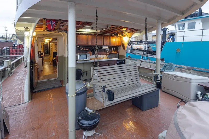 Slide: The Image of 1943 Custom Navy Tug with outdoor seating and grill on deck. - 4