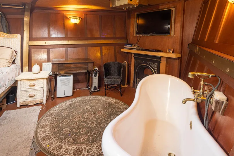 Slide: The Image of Luxurious 1943 custom Navy tug interior with vintage bathtub, wooden paneling, and elegant decor. - 40