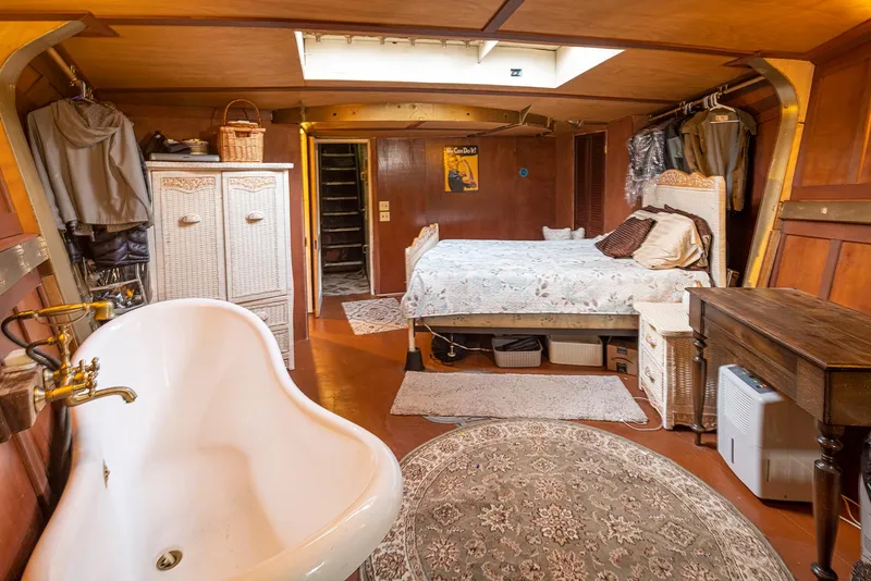 Slide: The Image of Cozy 1943 Custom Navy Tug interior with bed, bathtub, and vintage decor. - 41