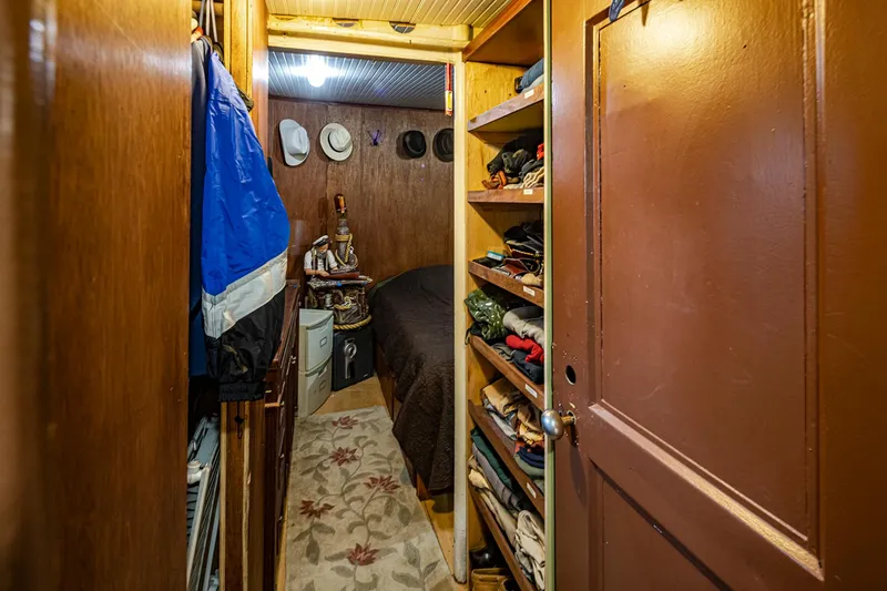 Slide: The Image of Cozy cabin interior of a 1943 Custom Navy Tug, featuring wooden shelves and a small bed. - 43