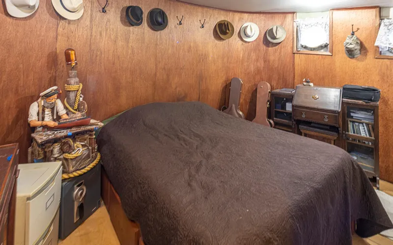 Slide: The Image of Cozy cabin interior with hats, nautical decor, and vintage furniture on a 1943 custom Navy tug. - 44