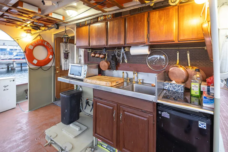 Slide: The Image of 1943 Custom Navy Tug kitchen with wooden cabinets, sink, and nautical decor. - 9