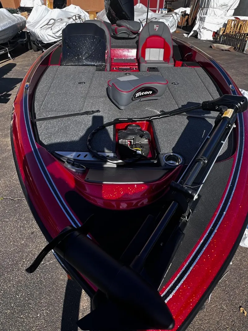 Slide: The Image of 2023 Triton 18 TrX bass boat with red exterior and fishing equipment. - 5