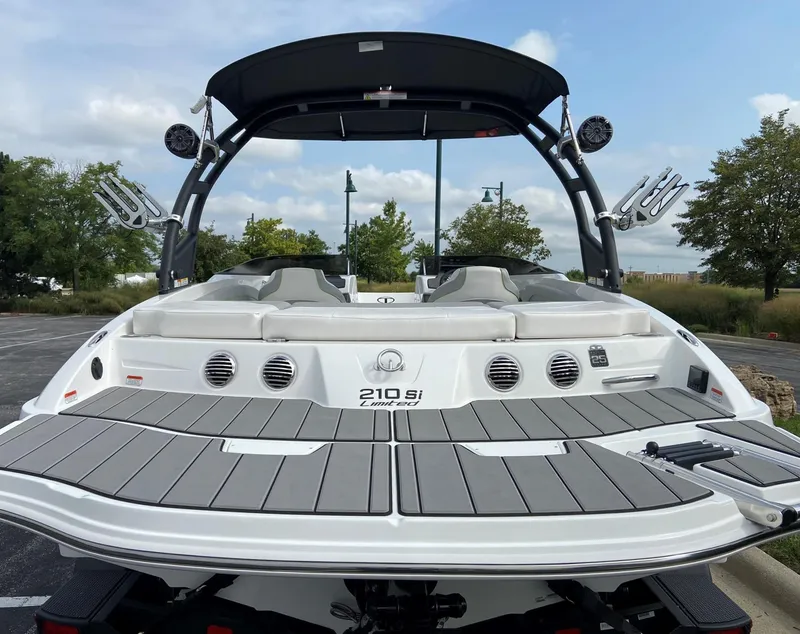 Slide: The Image of 2023 Tahoe 210 Si Limited boat, rear view, docked outdoors. - 2