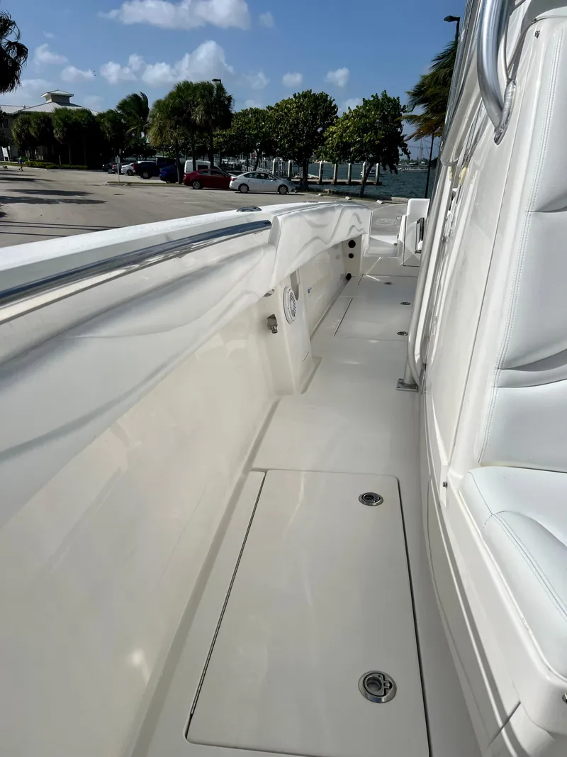 Slide: The Image of 2009 Spectre Sportfish boat deck with white seating and coastal background. - 21