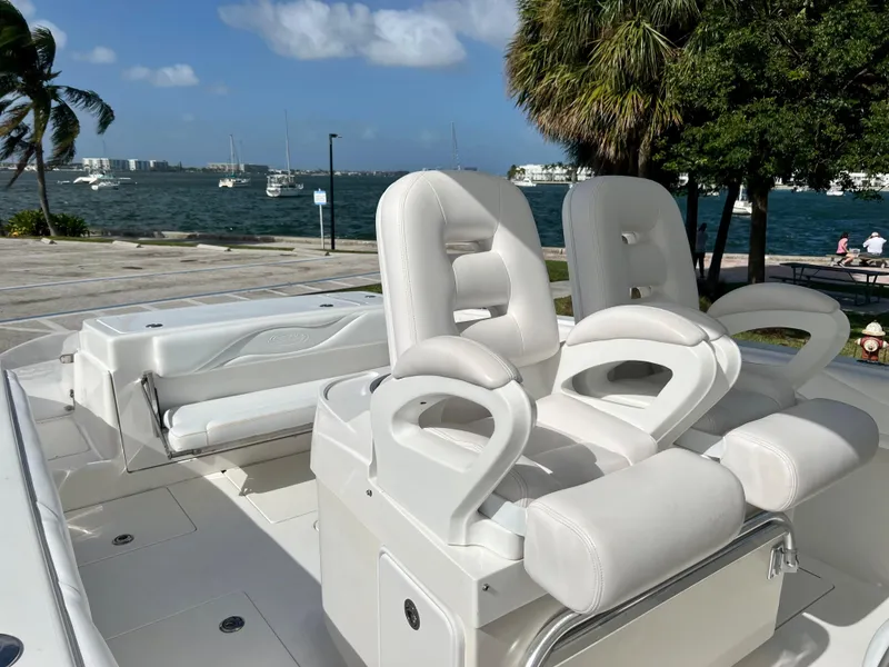 Slide: The Image of 2009 Spectre Sportfish boat with white leather seats docked near a scenic waterfront. - 23