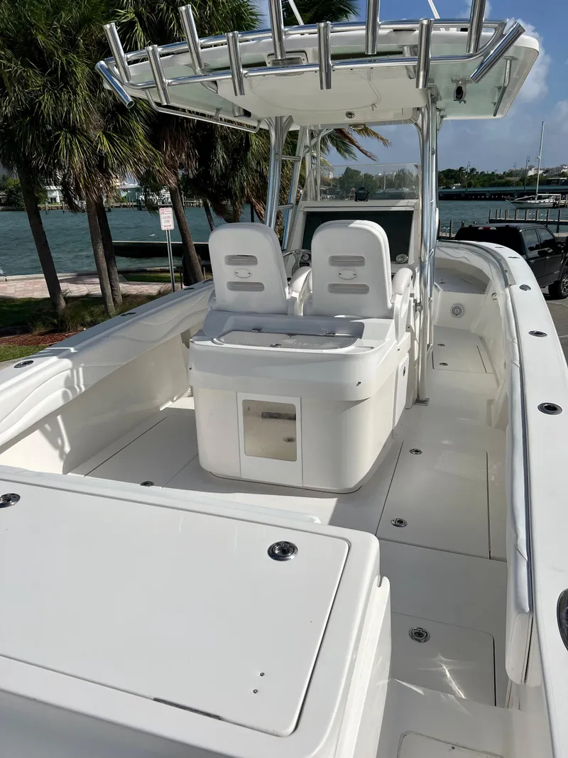 Slide: The Image of 2009 Spectre Sportfish boat with dual seats and T-top, docked near palm trees. - 25