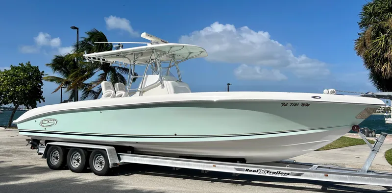 Slide: The Image of 2009 Spectre Sportfish boat on a trailer, parked near palm trees and water. - 3