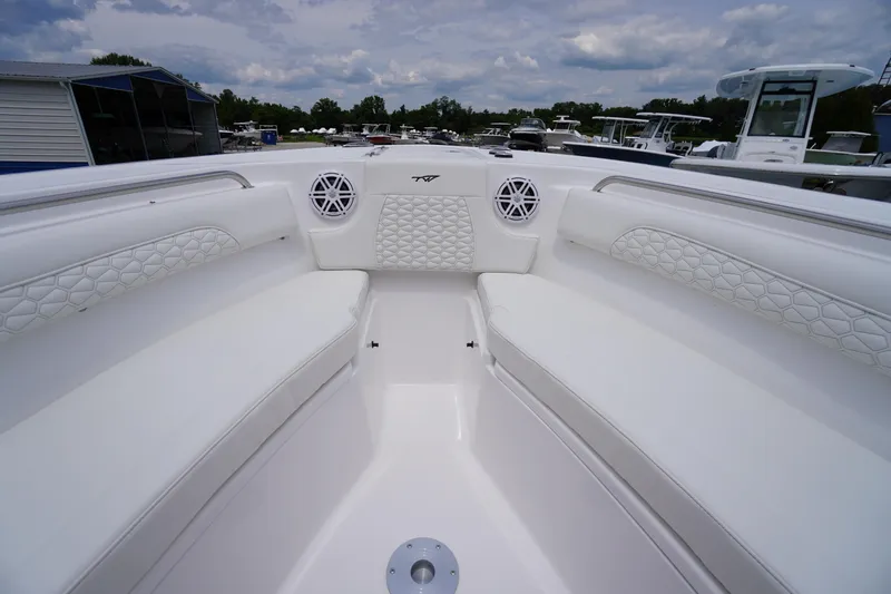 Slide: The Image of 2026 Tidewater 232 SS boat interior with white cushioned seating and speakers. - 16