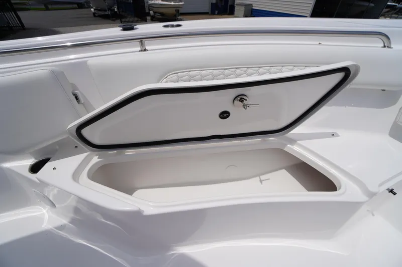 Slide: The Image of 2026 Tidewater 232 SS boat storage compartment with open hatch and key lock. - 21