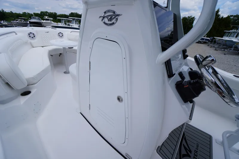 Slide: The Image of 2026 Tidewater 232 SS boat interior with seating, steering wheel, and storage compartment. - 30