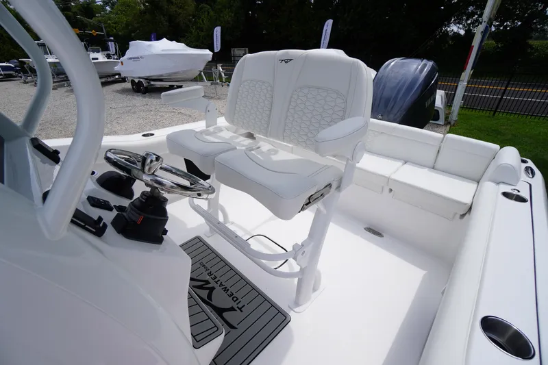 Slide: The Image of 2026 Tidewater 232 SS boat interior with dual white captain's chairs and steering console. - 43