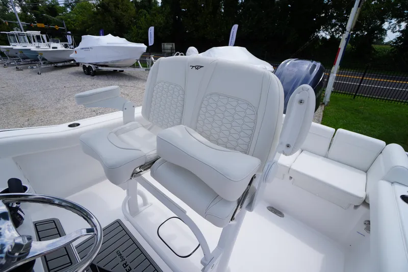 Slide: The Image of 2026 Tidewater 232 SS boat interior with white cushioned seating and steering wheel. - 44