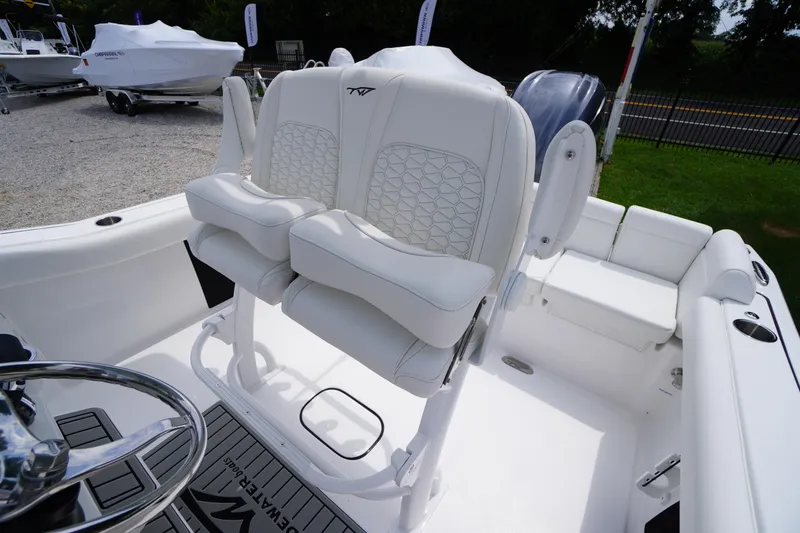 Slide: The Image of 2026 Tidewater 232 SS boat interior with white cushioned seating and steering wheel. - 45