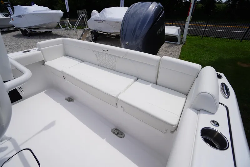 Slide: The Image of 2026 Tidewater 232 SS boat with white seating and Yamaha engine in a showroom. - 49