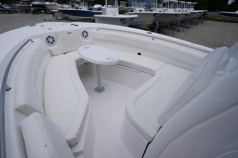 Slide: The Image of 2026 Tidewater 232 SS boat interior with white seating and table, docked among other boats. - 8