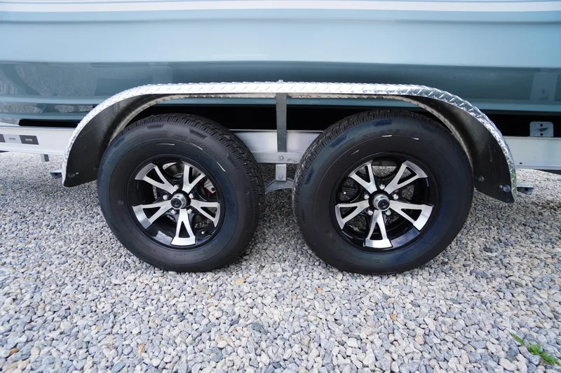 Slide: The Image of Trailer wheels of a 2026 Tidewater 232 SS boat on gravel surface. - 83