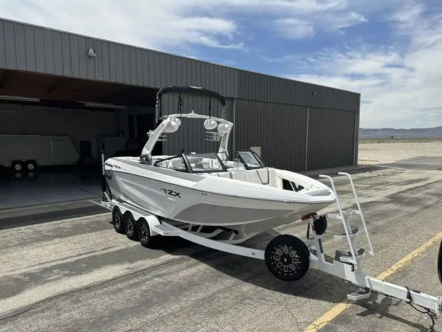 Slide: The Image of 2021 Tigé 25ZX boat on trailer outside hangar. - 2
