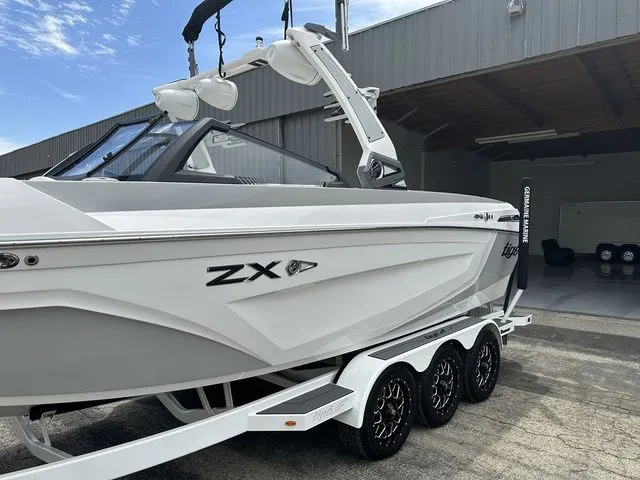 Slide: The Image of 2021 Tigé 25ZX boat on trailer outside garage. - 4