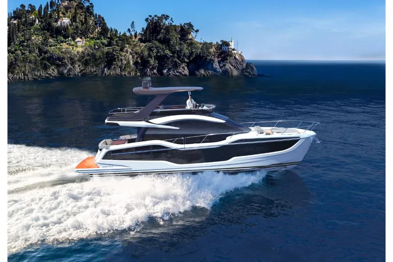 Slide: The Image of 2023 Galeon 560 Fly luxury yacht cruising near a scenic coastline. - 3