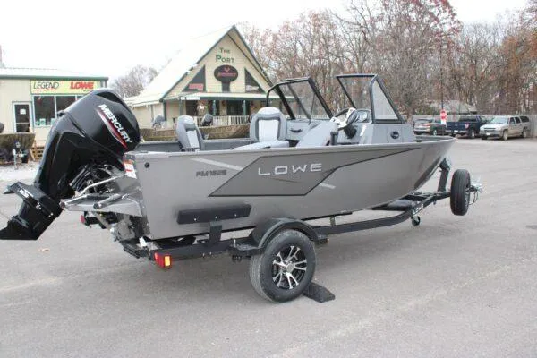 Slide: The Image of 2023 Lowe Fishing Machine 162 boat on trailer, parked outdoors. - 2