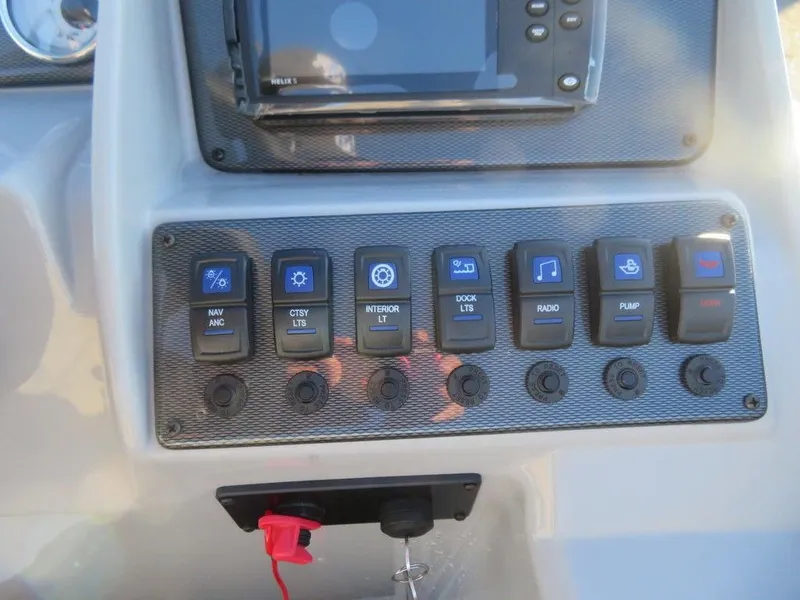 Slide: The Image of Control panel of 2023 Starcraft EX 22 C boat with various switches and a display screen. - 11