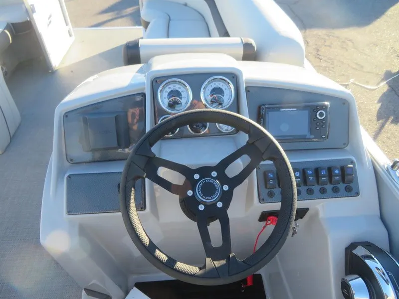 Slide: The Image of 2023 Starcraft EX 22 C boat dashboard with steering wheel and control panel. - 16